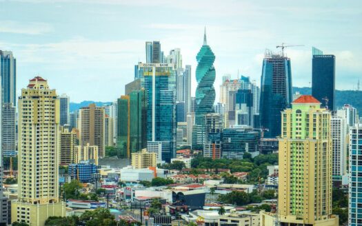 City skyline with tall modern skyscrapers and mid-rise buildings in a tropical urban area, blue sky above
