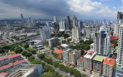 Aerial view of a dense city skyline with tall apartment buildings and streets below.