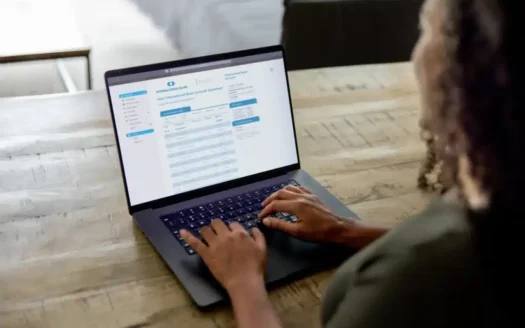 FBAR-vs-FATCA-1024x683 - Panama Elite Homes Person typing on a laptop at a wooden table, with an online banking page on the screen