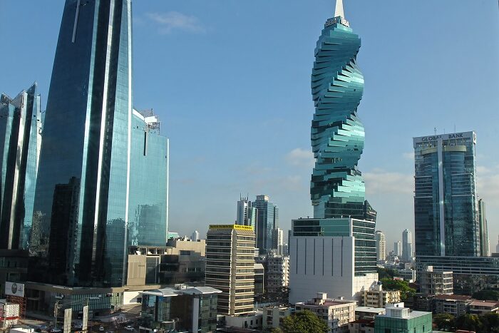 Bangkok skyline with a twisting green high-rise (King Power Mahanakorn) against a blue sky.